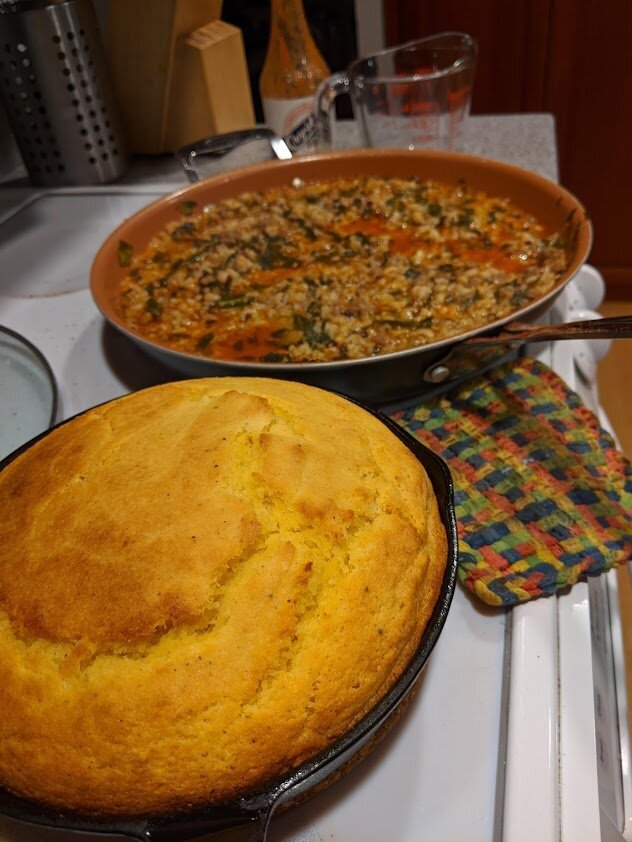 I can’t say how many comfort pans of buttermilk cornbread I’ve made in the past little bit, but the number is in the “a LOT” range  [Photo: yellow cornbread in cast iron skillet next to black eyed peas and rice with pot liquor]